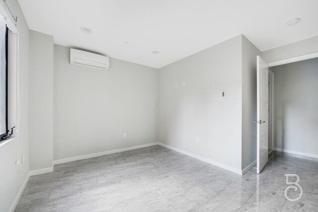 31-10 28th Rd Unit 1A, Astoria, NY 11102 - spare room featuring a wall mounted AC and baseboards
