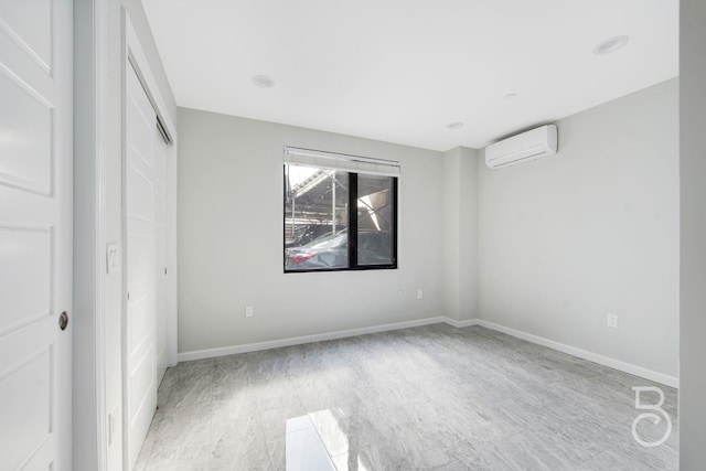 31-10 28th Rd Unit 1A, Astoria, NY 11102 - unfurnished bedroom featuring a wall unit AC, baseboards, wood finished floors, and a closet