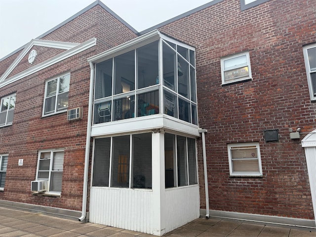 284 Central Ave Unit D-6, Lawrence, NY 11559 - view of home's exterior featuring a sunroom, brick siding, and cooling unit