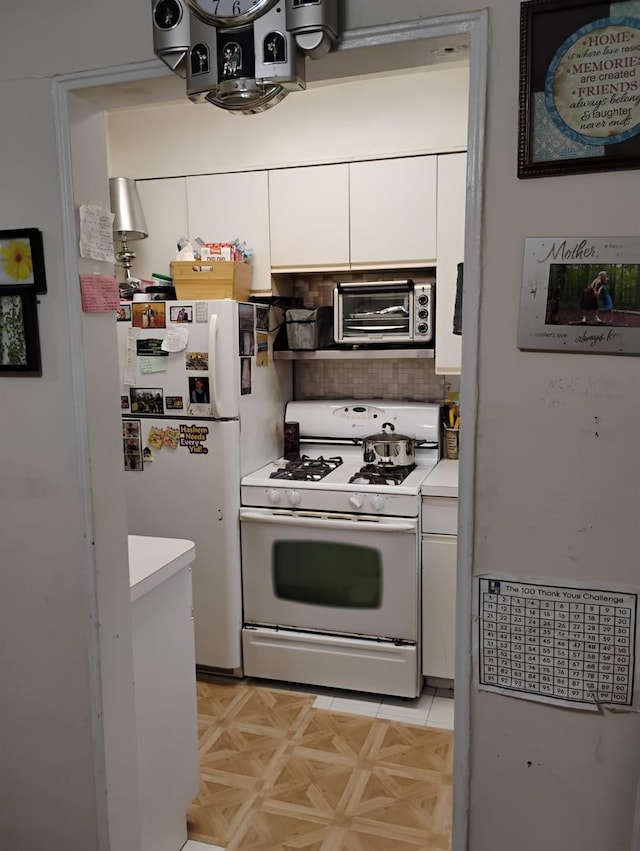 284 Central Ave Unit D-6, Lawrence, NY 11559 - kitchen featuring white appliances, white cabinets, light countertops, and decorative backsplash