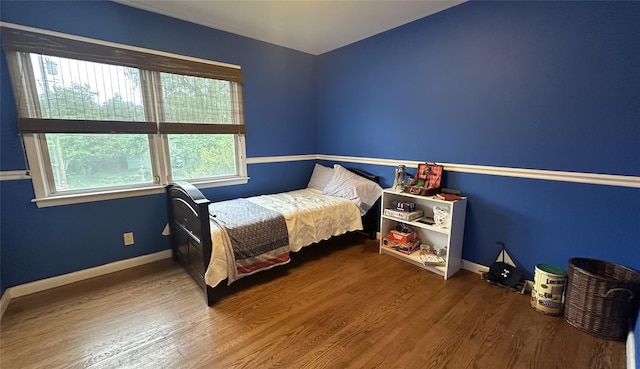 bedroom with wood finished floors and baseboards