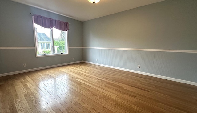 unfurnished room with wood finished floors and baseboards