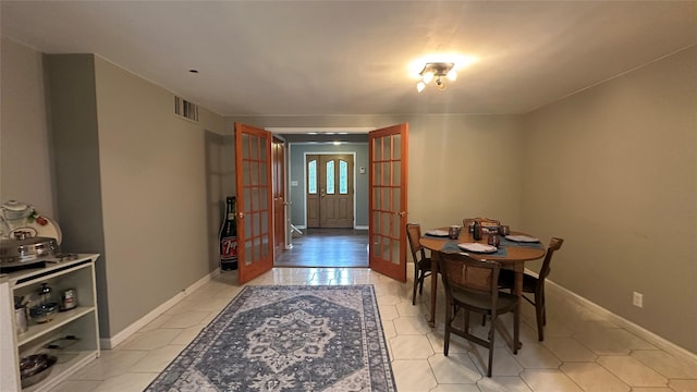 dining room featuring french doors, light tile patterned floors, and baseboards
