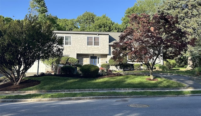 view of front of house featuring stone siding and a front yard
