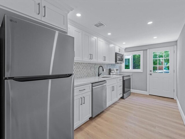 7 Pal Way, Plainview, NY 11803 - kitchen with stainless steel appliances, a sink, white cabinets, tasteful backsplash, and recessed lighting