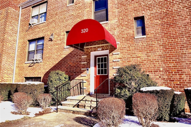 320 Richbell Rd Unit A4, Mamaroneck, NY 10543 - snow covered property entrance featuring cooling unit and brick siding