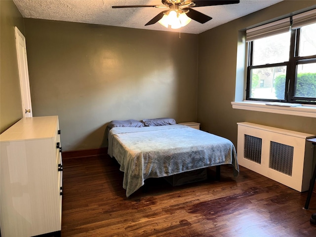 320 Richbell Rd Unit A4, Mamaroneck, NY 10543 - bedroom featuring radiator, dark wood-type flooring, a textured ceiling, a ceiling fan, and baseboards