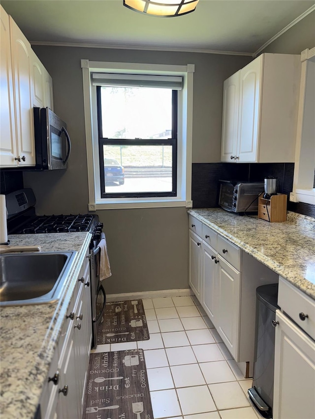 320 Richbell Rd Unit A4, Mamaroneck, NY 10543 - kitchen featuring stainless steel range with gas stovetop, crown molding, white cabinetry, light tile patterned floors, and a sink