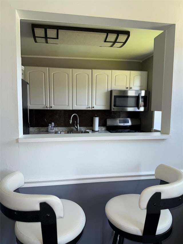 320 Richbell Rd Unit A4, Mamaroneck, NY 10543 - kitchen featuring stainless steel appliances, white cabinets, a breakfast bar area, and a sink
