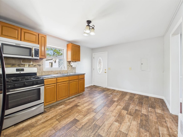 95 State Ave, Wyandanch, NY 11798 - kitchen featuring stainless steel appliances, a sink, backsplash, and light wood finished floors