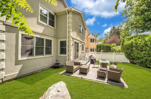 rear view of house featuring stucco siding, outdoor lounge area, and a patio