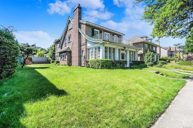 view of home's exterior with a balcony, a chimney, and brick siding