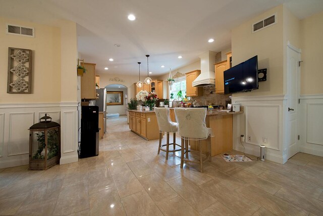 16 Kukas Rd, Monticello, NY 12701 - kitchen featuring a decorative wall, a peninsula, recessed lighting, custom range hood, and a wainscoted wall