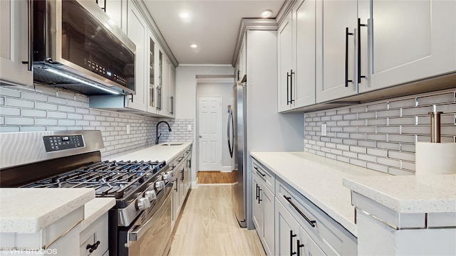 kitchen with appliances with stainless steel finishes, backsplash, light stone countertops, recessed lighting, and ornamental molding