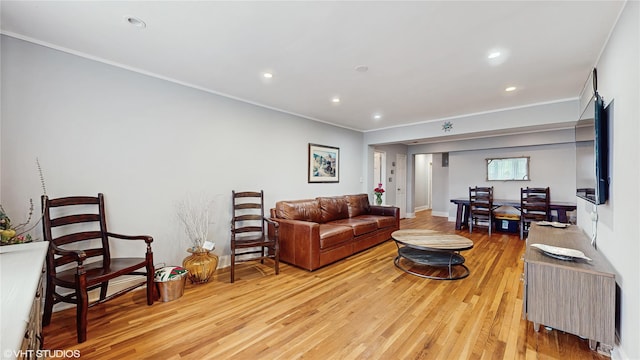 living room featuring ornamental molding, light wood-style floors, and recessed lighting