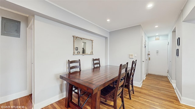 dining space with electric panel, light wood-type flooring, recessed lighting, and baseboards
