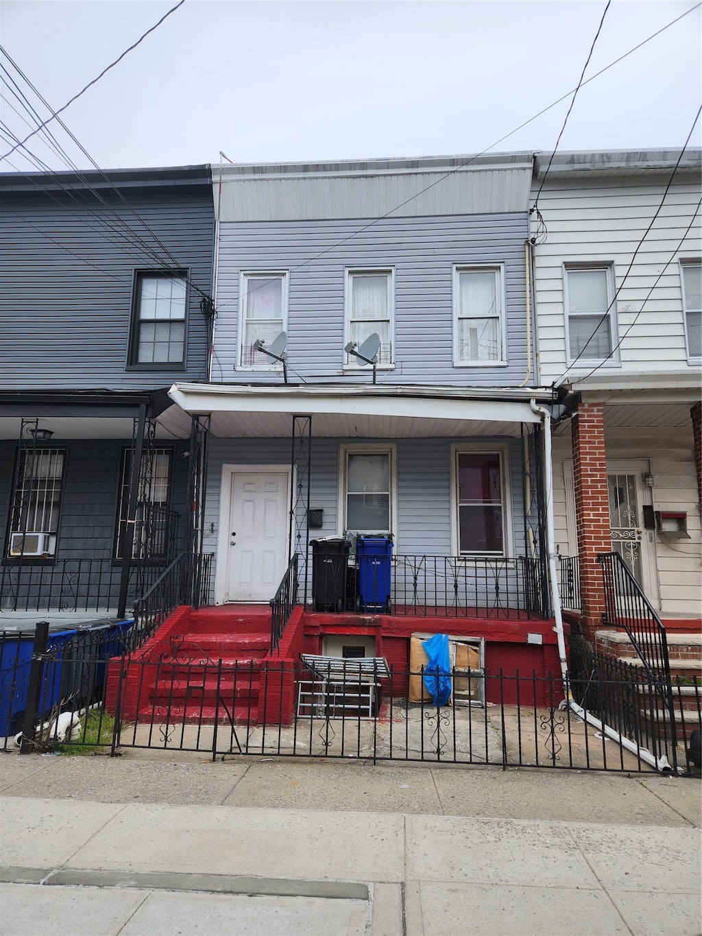 townhome / multi-family property featuring a porch and a fenced front yard