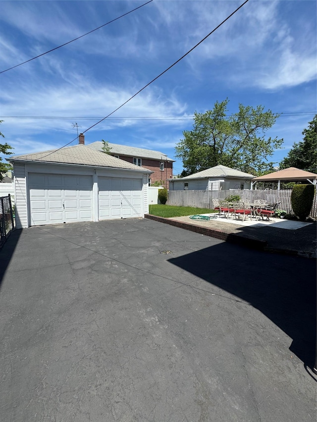 1039 Van Nest Ave, Bronx, NY 10461 - view of side of home featuring fence, an outdoor structure, a detached garage, and a chimney
