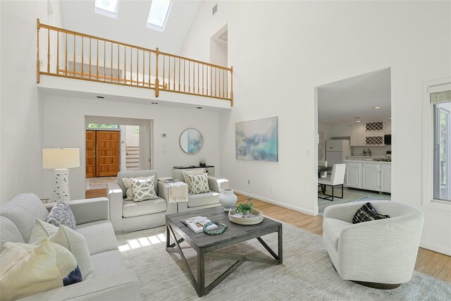 14 Cross Rd, Cortlandt Manor, NY 10567 - living area featuring a towering ceiling, light wood-style floors, plenty of natural light, baseboards, and a skylight