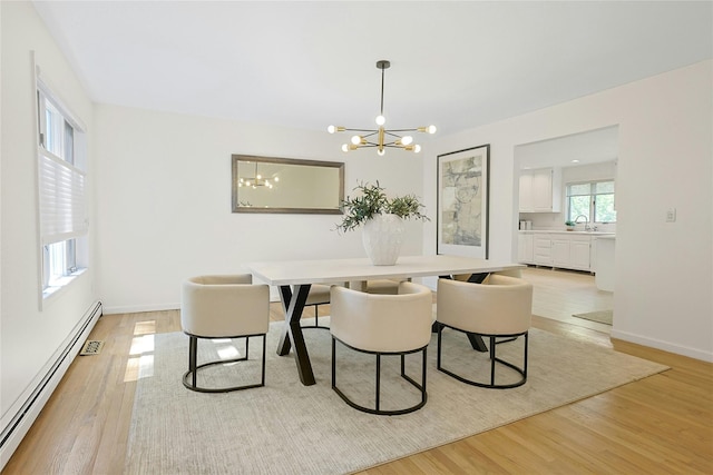 14 Cross Rd, Cortlandt Manor, NY 10567 - dining space featuring a baseboard heating unit, a chandelier, light wood finished floors, and baseboards