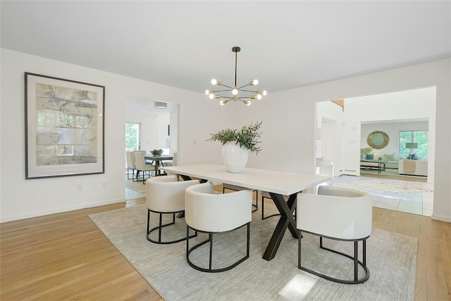 14 Cross Rd, Cortlandt Manor, NY 10567 - dining space featuring light wood-style flooring, a chandelier, healthy amount of natural light, and baseboards