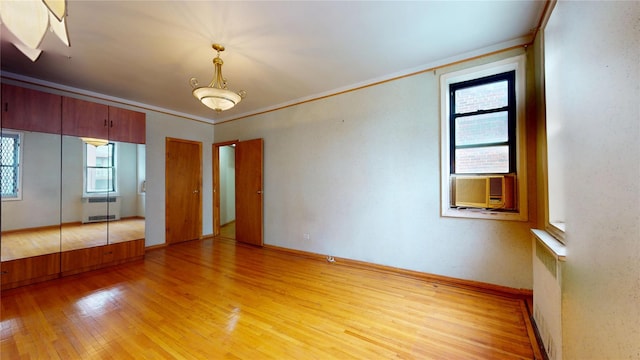 3250 Coney Island Ave Unit E15, Brooklyn, NY 11235 - unfurnished room featuring light wood-type flooring, radiator, crown molding, cooling unit, and a chandelier