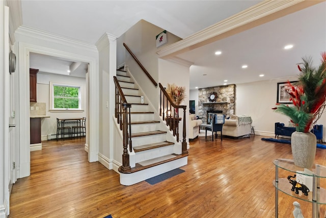 96 Warren St, Somers, NY 10589 - staircase with a fireplace, wood-type flooring, a baseboard radiator, crown molding, and baseboards