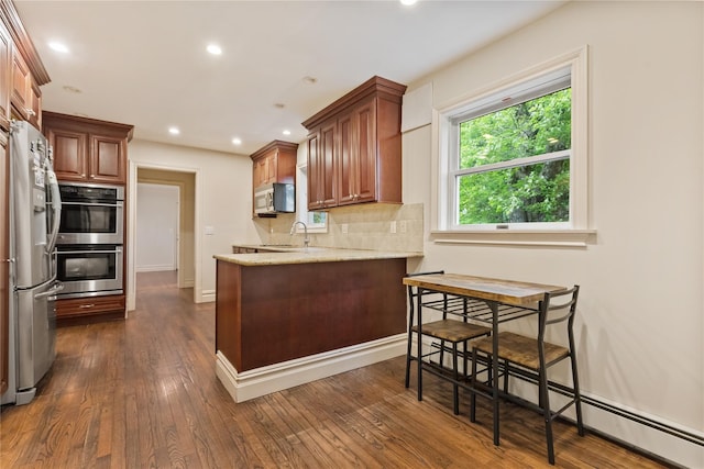 96 Warren St, Somers, NY 10589 - kitchen featuring appliances with stainless steel finishes, a peninsula, dark wood-type flooring, recessed lighting, and light stone countertops