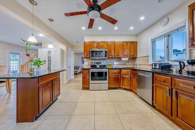 34 Marksman Ln, Levittown, NY 11756 - kitchen featuring appliances with stainless steel finishes, brown cabinetry, a sink, decorative backsplash, and ceiling fan