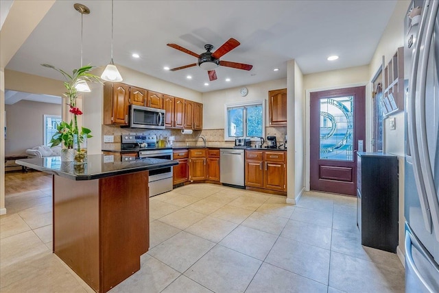 34 Marksman Ln, Levittown, NY 11756 - kitchen featuring appliances with stainless steel finishes, dark countertops, brown cabinetry, tasteful backsplash, and a ceiling fan