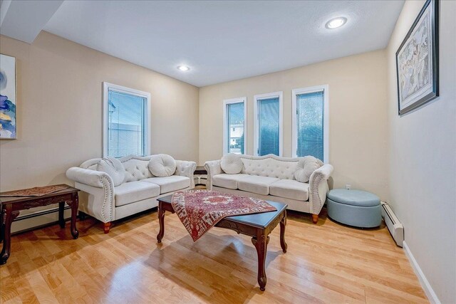 34 Marksman Ln, Levittown, NY 11756 - living room with a baseboard heating unit, light wood-type flooring, recessed lighting, and baseboards