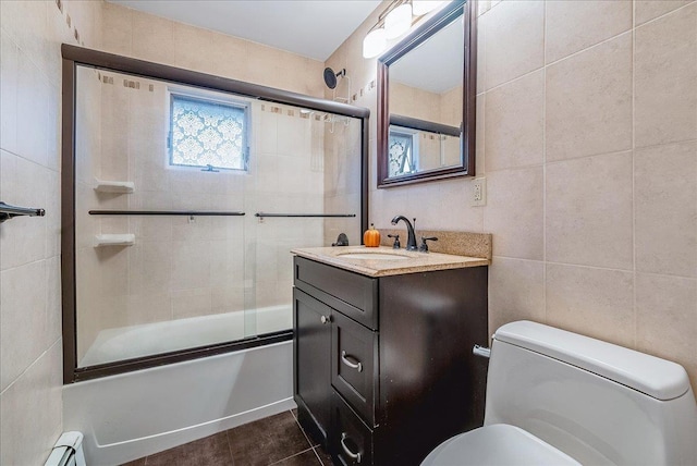 34 Marksman Ln, Levittown, NY 11756 - full bathroom with toilet, tile walls, bath / shower combo with glass door, vanity, and tile patterned flooring