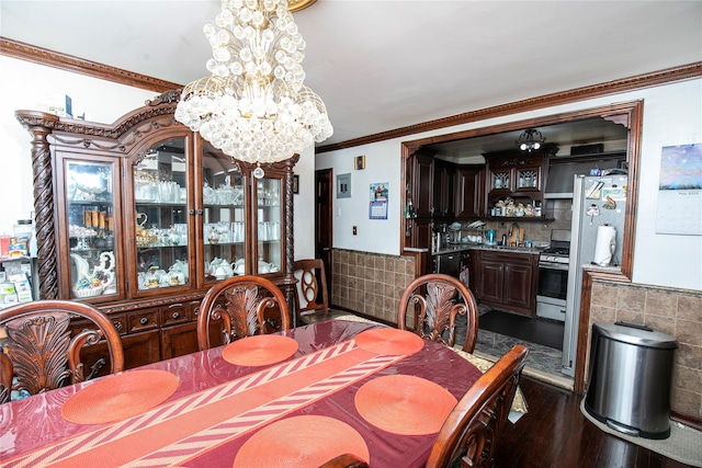 10124 78th St, Ozone Park, NY 11416 - dining room featuring a chandelier, dark wood finished floors, crown molding, tile walls, and a wainscoted wall