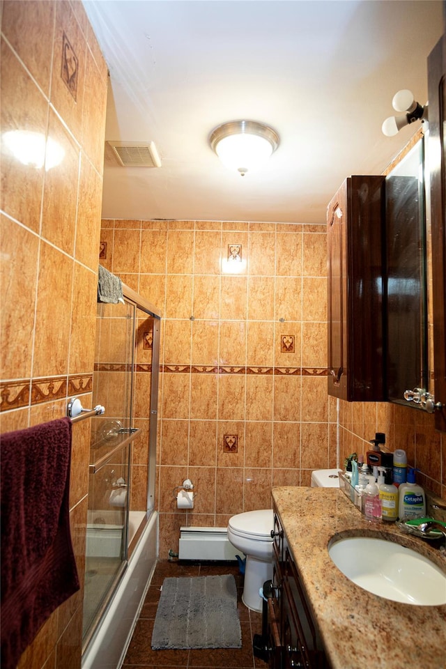 10124 78th St, Ozone Park, NY 11416 - bathroom featuring a baseboard radiator, tile walls, vanity, shower / bath combination with glass door, and toilet