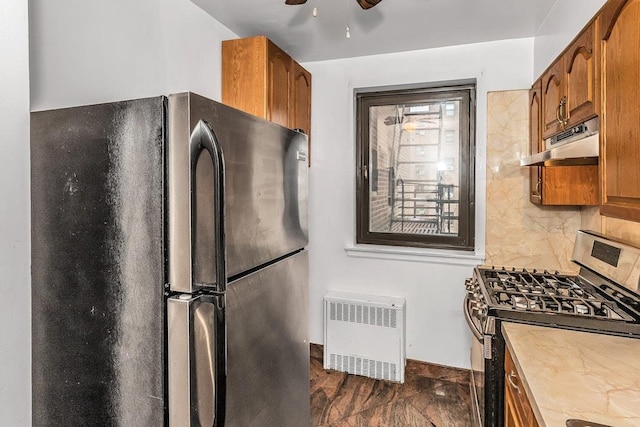 87-40 Francis Lewis Blvd Unit B38, Queens Village, NY 11427 - kitchen featuring appliances with stainless steel finishes, under cabinet range hood, radiator, ceiling fan, and brown cabinets