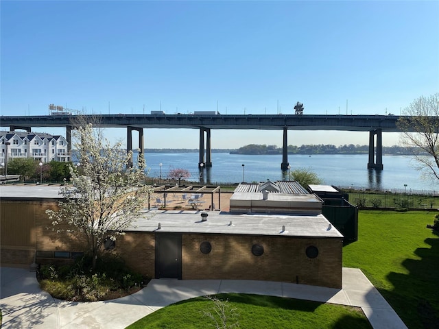 wooden deck with a water view and a lawn