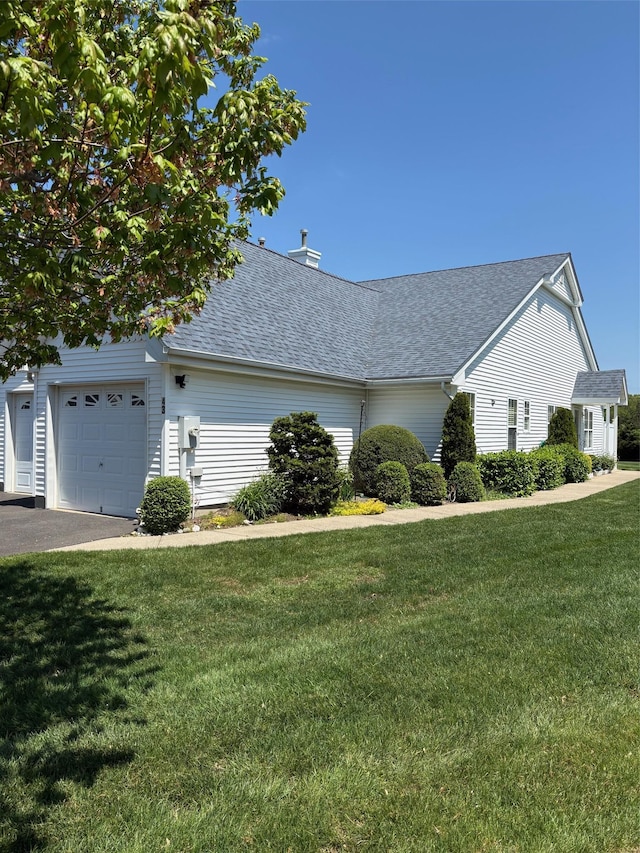 43 Summerfield Ln N Unit 43, Aquebogue, NY 11901 - view of property exterior featuring roof with shingles, a lawn, an attached garage, and driveway