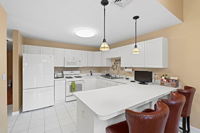 43 Summerfield Ln N Unit 43, Aquebogue, NY 11901 - kitchen with white appliances, a sink, a peninsula, light countertops, and decorative light fixtures
