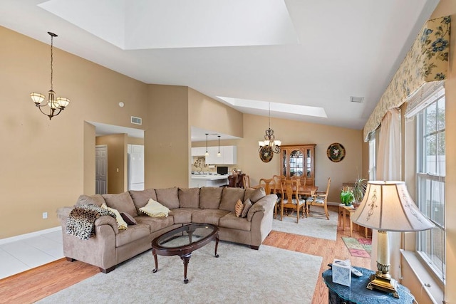43 Summerfield Ln N Unit 43, Aquebogue, NY 11901 - living room with a chandelier, lofted ceiling, a skylight, light wood-style floors, and plenty of natural light