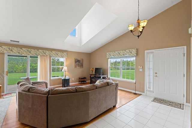 43 Summerfield Ln N Unit 43, Aquebogue, NY 11901 - living area with high vaulted ceiling, a chandelier, plenty of natural light, a skylight, and baseboards