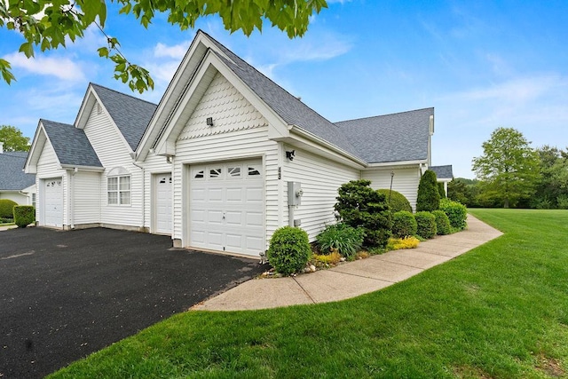 43 Summerfield Ln N Unit 43, Aquebogue, NY 11901 - view of home's exterior with asphalt driveway, an attached garage, a lawn, and a shingled roof