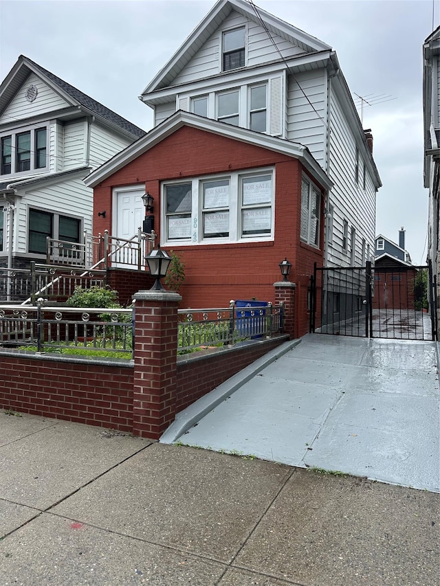 view of front of home featuring a fenced front yard, a chimney, and brick siding