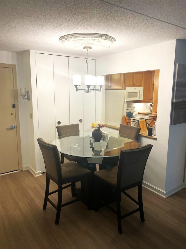 300 High Point Dr Unit 514, Hartsdale, NY 10530 - dining space with dark wood-style floors, a textured ceiling, a chandelier, and baseboards