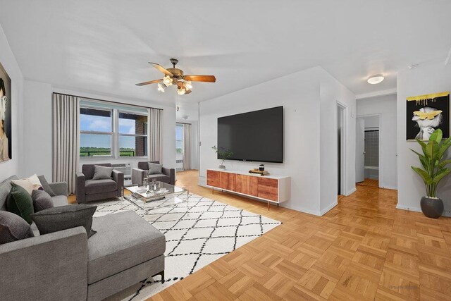 living room with baseboards and a ceiling fan