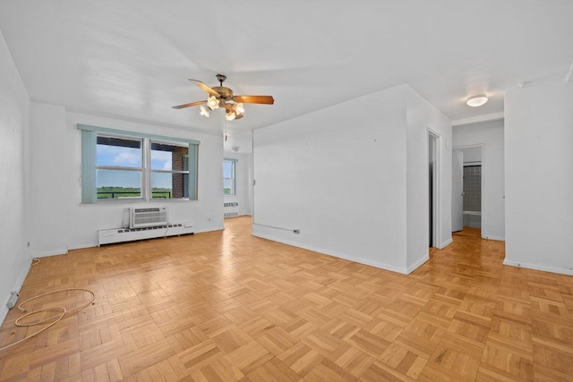 unfurnished room with a baseboard radiator, a ceiling fan, and baseboards