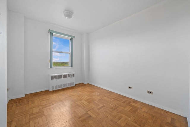 unfurnished room with radiator and baseboards