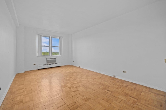 empty room with baseboards, a baseboard radiator, and a wall mounted air conditioner