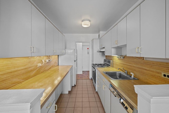 kitchen featuring white appliances, a sink, under cabinet range hood, and backsplash