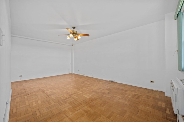 empty room featuring a ceiling fan and baseboards