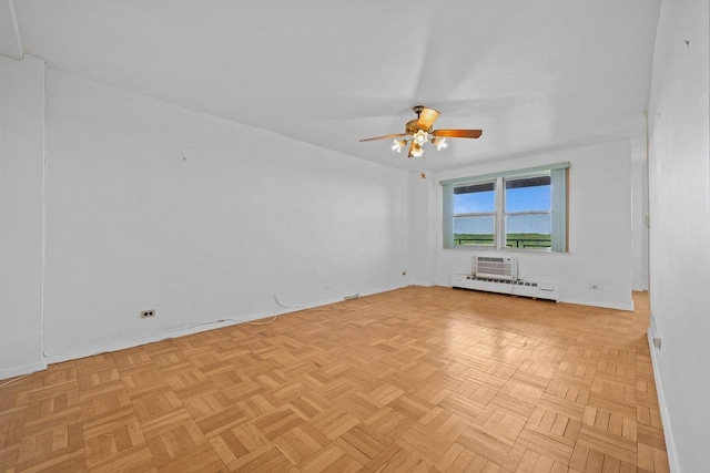 unfurnished room featuring ceiling fan, a baseboard radiator, baseboards, and a wall mounted air conditioner